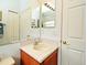 A well-lit bathroom with a wood vanity, and a large mirror at 2591 Oneida Loop, Kissimmee, FL 34747