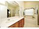 Bright bathroom featuring a double sink vanity, a large mirror, and a separate shower and bathtub at 2591 Oneida Loop, Kissimmee, FL 34747