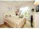 A cozy bedroom featuring a floral bedspread, arched window, and soft natural light at 2591 Oneida Loop, Kissimmee, FL 34747