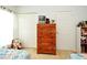 A cozy bedroom features wooden dresser with toys and a window at 2591 Oneida Loop, Kissimmee, FL 34747