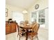 Cozy dining area with a round wood table, seating for four, and natural light from large windows at 2591 Oneida Loop, Kissimmee, FL 34747
