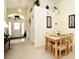 Bright dining area with chandelier, a lovely front door view and a simple four-seat wooden table at 2591 Oneida Loop, Kissimmee, FL 34747