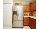 Well-equipped kitchen featuring a stainless steel refrigerator and wooden cabinets at 2591 Oneida Loop, Kissimmee, FL 34747