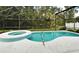 Private screened-in pool and spa combo with surrounding lush greenery, perfect for leisure at 2591 Oneida Loop, Kissimmee, FL 34747