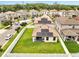 An aerial view of a home with a large, green backyard, solar panels, and a neighborhood street at 2824 Noble Crow Dr, Kissimmee, FL 34744