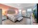Bedroom features silver furniture, pink accent wall, and large windows for natural light at 2824 Noble Crow Dr, Kissimmee, FL 34744