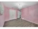 Bedroom with pale pink walls, hardwood flooring, and a chandelier at 2824 Noble Crow Dr, Kissimmee, FL 34744