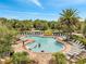 A vibrant community pool area with lush landscaping, comfortable loungers, and clear blue water at 2824 Noble Crow Dr, Kissimmee, FL 34744