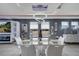 Bright dining room with glass table, white chairs, modern chandelier, and stylish decor at 2824 Noble Crow Dr, Kissimmee, FL 34744