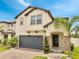 Two-story home with gray garage door, manicured shrubbery, and light stone entryway at 2824 Noble Crow Dr, Kissimmee, FL 34744