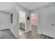 Hallway with vinyl floors leads to a bathroom with granite counters and a pink bedroom with a chandelier at 2824 Noble Crow Dr, Kissimmee, FL 34744