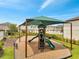 A well-maintained playground featuring slides, a covered area, and lush landscaping in a Gathering-friendly community at 2824 Noble Crow Dr, Kissimmee, FL 34744