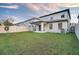 The backyard features a covered patio, a well-maintained lawn, and a white vinyl fence at 2833 Noble Crow Dr, Kissimmee, FL 34744