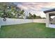 A spacious backyard features a well-manicured lawn surrounded by a pristine white fence for privacy at 2833 Noble Crow Dr, Kissimmee, FL 34744