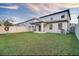 The backyard features a covered patio, a well-maintained lawn, and a white vinyl fence at 2833 Noble Crow Dr, Kissimmee, FL 34744
