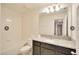Bathroom showcasing a granite counter, ample mirror, tub and dark wood vanity at 2833 Noble Crow Dr, Kissimmee, FL 34744