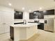 Modern kitchen with stainless steel appliances, a large island, and dark cabinetry at 2833 Noble Crow Dr, Kissimmee, FL 34744
