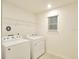 Bright laundry room with two machines, rack, window and neutral walls at 2833 Noble Crow Dr, Kissimmee, FL 34744