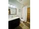 Modern bathroom with a single sink vanity, tiled flooring, decorative mirror, and a shower with a curtain at 2862 Grasmere View Pkwy, Kissimmee, FL 34746
