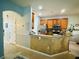 Open kitchen featuring granite countertops, wooden cabinetry, stainless appliances, and bar seating at 2862 Grasmere View Pkwy, Kissimmee, FL 34746