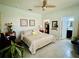 Tranquil main bedroom featuring tile flooring, a ceiling fan, and convenient access to the ensuite bathroom at 2862 Grasmere View Pkwy, Kissimmee, FL 34746
