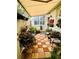 Cozy outdoor patio with a checkered tile floor, an awning, and lush potted plants creating a serene retreat at 2862 Grasmere View Pkwy, Kissimmee, FL 34746