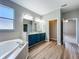 Bathroom with a large tub, gray walls, wood-look floors, and double sink vanity at 301 Terranova Blvd, Winter Haven, FL 33884