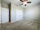 Bedroom with neutral carpet, window, ceiling fan, and closet doors at 301 Terranova Blvd, Winter Haven, FL 33884