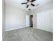 Bedroom with light gray walls, ceiling fan, carpet, and double door closet at 301 Terranova Blvd, Winter Haven, FL 33884
