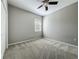 This bedroom offers neutral carpet and walls with a ceiling fan and a window at 301 Terranova Blvd, Winter Haven, FL 33884