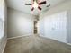 Bedroom features neutral carpet, closet, window, and ceiling fan at 301 Terranova Blvd, Winter Haven, FL 33884