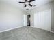 Bedroom with light gray walls, ceiling fan, carpet, and double door closet at 301 Terranova Blvd, Winter Haven, FL 33884