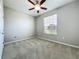 Bedroom with a ceiling fan, large window, and neutral colored carpet at 301 Terranova Blvd, Winter Haven, FL 33884