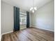 Open dining area with modern chandelier, large window, and wood-look flooring at 301 Terranova Blvd, Winter Haven, FL 33884