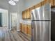 Bright kitchen with stainless steel refrigerator, wooden cabinets, and light-colored floors at 301 Terranova Blvd, Winter Haven, FL 33884
