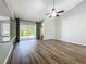 Open-concept living room with wood floors, a ceiling fan, and sliding glass door at 301 Terranova Blvd, Winter Haven, FL 33884