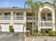 Inviting exterior of a two-story condo with palm tree, private garage, and balconies on both floors at 3205 Sabal Palms Ct # A, Kissimmee, FL 34747