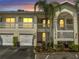 Exterior shot of the townhome with garages and lit balconies at 3205 Sabal Palms Ct # A, Kissimmee, FL 34747