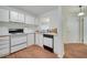 Well-lit kitchen features white cabinets, black and white appliances and wood-look vinyl floors at 3205 Sabal Palms Ct # A, Kissimmee, FL 34747
