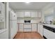 Well-lit kitchen features white cabinets, black and white appliances and wood-look vinyl floors at 3205 Sabal Palms Ct # A, Kissimmee, FL 34747