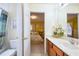 Bright bathroom with a marble topped vanity leading to a bedroom with yellow walls and patterned bedding at 344 Cherokee Ave, Haines City, FL 33844