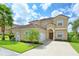 Two-story home with terra cotta roof, attached garage, well-manicured lawn, and ample driveway space at 344 Cherokee Ave, Haines City, FL 33844