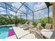 Screened-in pool deck with lounge chairs and view of serene lake and surrounding greenery at 344 Cherokee Ave, Haines City, FL 33844