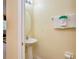 A well lit half bathroom with pedestal sink, mirror, towel and toilet paper at 344 Cherokee Ave, Haines City, FL 33844