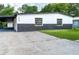 Charming one-story home with carport, showcasing black and white color scheme, and a well-maintained yard at 3524 Hage Way, Orlando, FL 32805