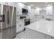 Renovated kitchen featuring white cabinets, stainless steel appliances, quartz countertops, and modern flooring at 3524 Hage Way, Orlando, FL 32805