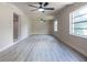 Bright living room featuring modern vinyl flooring, ceiling fans, neutral paint, and abundant natural light at 3524 Hage Way, Orlando, FL 32805
