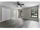 Bright bedroom showcasing wood floors, modern ceiling fan, and an adjacent bathroom at 3623 Tree Line Way, St Cloud, FL 34769