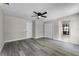 Neutral-toned bedroom has wood floors, a ceiling fan, closet, and view to a bathroom at 3623 Tree Line Way, St Cloud, FL 34769