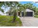 View of the home's front exterior showcasing a two-car garage and red front door at 3623 Tree Line Way, St Cloud, FL 34769
